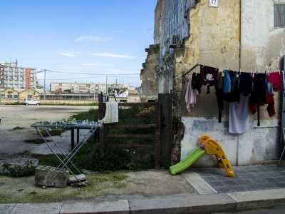 Di fronte alle edicole sventolano alcuni panni stesi e uno scivolo colorato